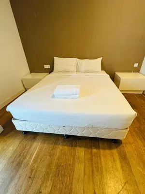 a large white bed in a room with wooden floors at Platinum Suites KLCC by Home stay in Kuala Lumpur