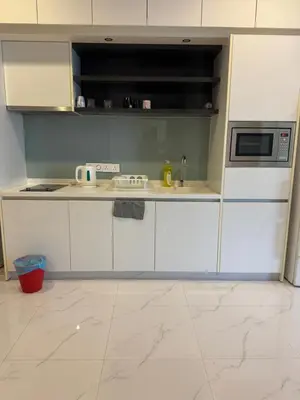 a kitchen with white cabinets and a microwave at Platinum Suites KLCC by Home stay in Kuala Lumpur