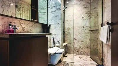 a bathroom with a toilet and a glass shower at Eaton Residence KLCC - J Home in Kuala Lumpur