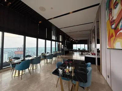 a restaurant with tables and chairs and large windows at Star Residence KLCC By Nexus 72 in Kuala Lumpur