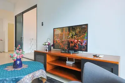 a living room with a television on a wooden entertainment center at Reizz Residence by Greenhome in Kuala Lumpur