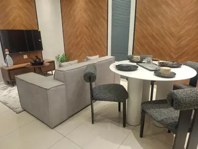 a living room with a table and chairs and a tv at Dorsett Residence by 