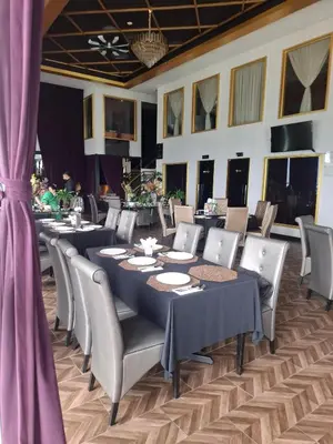 a dining room with tables and chairs and purple curtains at Dorsett Residence by 