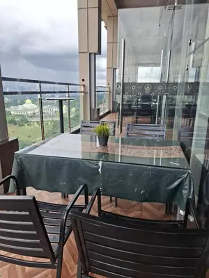a glass table and chairs on a balcony at Dorsett Residence by 