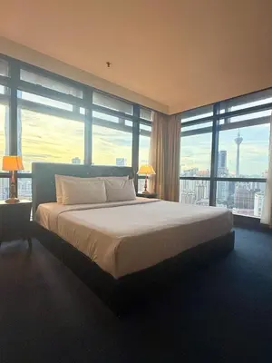 a bedroom with a large bed with large windows at Times square by Willow Trip in Kuala Lumpur