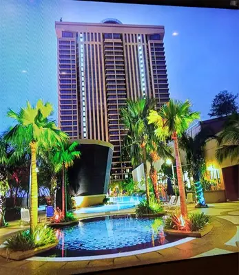 a hotel with palm trees in front of a building at KL Advice Suite At Times Square in Kuala Lumpur