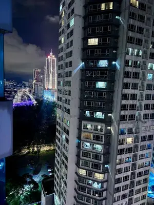 a tall building with its lights on at night at Mercu Summer suites KLCC by JK Privy Homes - 7 Pax Family Stay in Kuala Lumpur