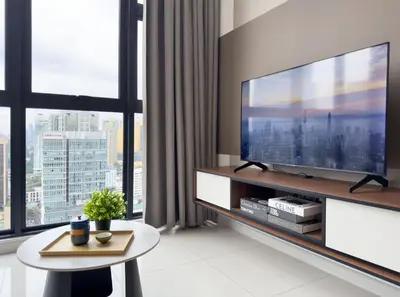 a living room with a large television and a table at Majestic Suites KLCC by KLIQ in Kuala Lumpur