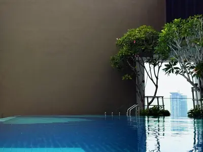 a swimming pool with trees on the side of a building at Majestic Suites KLCC by KLIQ in Kuala Lumpur