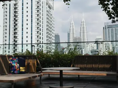 a table and benches in a city with tall buildings at Majestic Suites KLCC by KLIQ in Kuala Lumpur