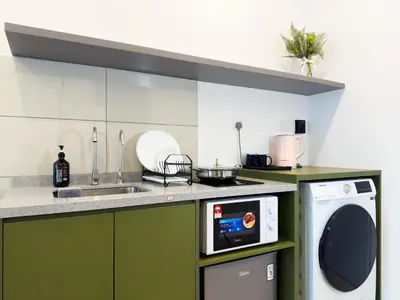 a kitchen with a sink and a washing machine at Majestic Suites KLCC by KLIQ in Kuala Lumpur