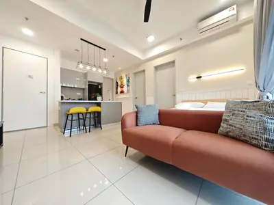 a living room with a couch and a kitchen at TRION The 107 Family Suites POOL VIEW in Kuala Lumpur