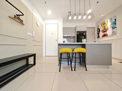 a kitchen with yellow stools at a counter at TRION The 107 Family Suites POOL VIEW in Kuala Lumpur