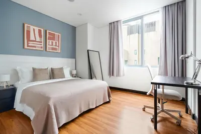 a bedroom with a bed and a desk and a window at Blueground Kampung Baru pool nr KL Tower KUL-9 in Kuala Lumpur