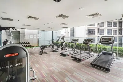 a gym with rows of treadmills and people on machines at Blueground Kampung Baru pool nr KL Tower KUL-9 in Kuala Lumpur