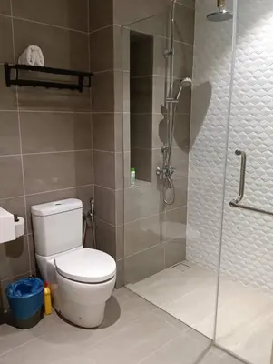 a bathroom with a toilet and a glass shower at Quill Resort Suites Star House in Kuala Lumpur
