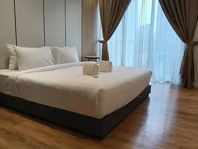 a bedroom with a large bed with white sheets at Quill Resort Suites Star House in Kuala Lumpur