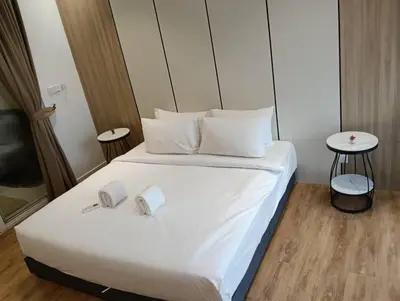 a bed with white sheets and pillows in a room at Quill Resort Suites Star House in Kuala Lumpur