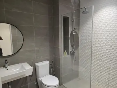 a bathroom with a shower and a toilet and a sink at Quill Resort Suites Star House in Kuala Lumpur