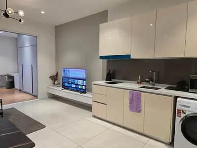 a kitchen with white cabinets and a flat screen tv at Quill Resort Suites Star House in Kuala Lumpur