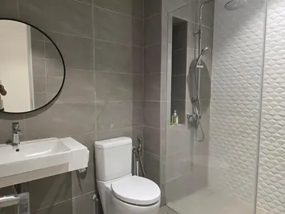 a bathroom with a shower and a toilet and a sink at Quill Resort Suites Star House in Kuala Lumpur