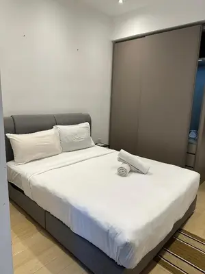 a bedroom with a large bed with white sheets at Eaton Residence KLCC by Majestic Hospitality in Kuala Lumpur