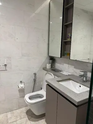 a white bathroom with a toilet and a sink at Eaton Residence KLCC by Majestic Hospitality in Kuala Lumpur