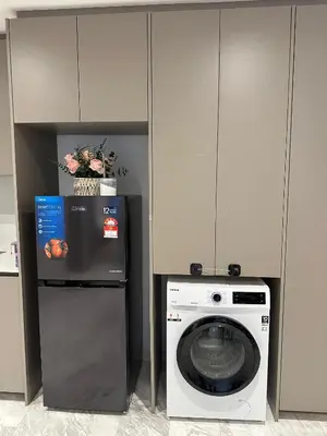 a kitchen with a washing machine and a refrigerator at Eaton Residence KLCC by Majestic Hospitality in Kuala Lumpur