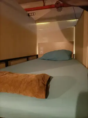a large bed in a small room with a pillow at Cozy Hostel City Central in Kuala Lumpur