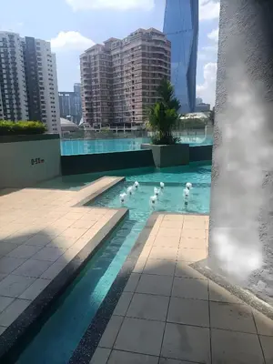 a pool with swans in the water with buildings at Cozy Hostel City Central in Kuala Lumpur