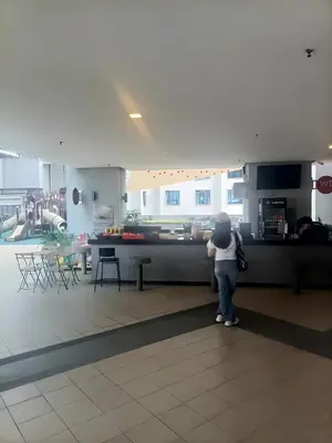 a child standing at a counter in a restaurant at Cozy Hostel City Central in Kuala Lumpur