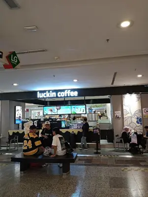 a group of people sitting on benches in a shopping mall at Royal Service Suite At Berjaya Times Square in Kuala Lumpur