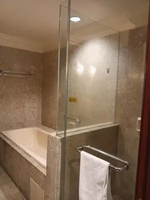a bathroom with a tub and a shower with a towel at Royal Service Suite At Berjaya Times Square in Kuala Lumpur
