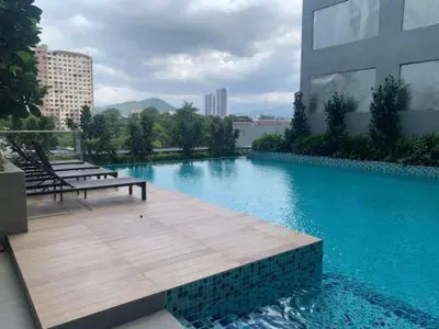 a swimming pool with a bench and a building at Neu Suite by Triple A in Kuala Lumpur