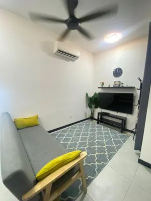 a living room with a couch and a ceiling fan at Neu Suite by Triple A in Kuala Lumpur