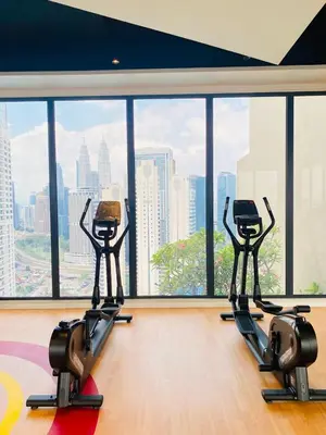 a gym with two exercise machines in front of a large window at City centre Majestice Suite KLCC in Kuala Lumpur
