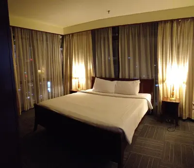 a large bed in a hotel room with two lamps at MY HOMEs TIMES SQUARE in Kuala Lumpur