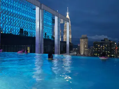 a group of people in a swimming pool with a city skyline at PLATINUM Suites KLCC at BBS in Kuala Lumpur