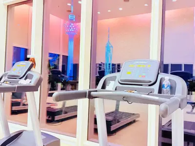 a gym with two machines in front of a mirror at PLATINUM Suites KLCC at BBS in Kuala Lumpur