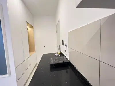 a bathroom with a black counter and white walls at Kuala Lumpur Suites Majestic Sky Pool in Kuala Lumpur