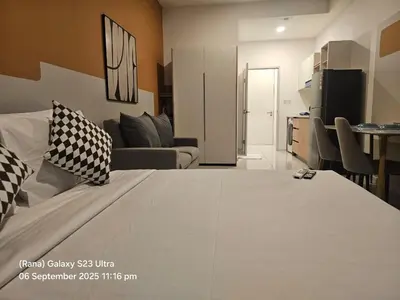 a bedroom with a large bed and a living room at Majestic Residence Kuala Lumpur in Kuala Lumpur