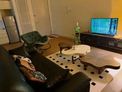 a living room with a black couch and a tv at Cheras KL Velocity Mall VR3 8pax MRT Maluri NAN JING STREET 焦赖吉隆坡 步行1分钟到 双威伟乐城&南京街 可容8人 in Kuala Lumpur
