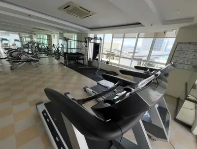 a gym with rows of treadmills and elliptical machines at Parkview Serviced Apartment in Kuala Lumpur