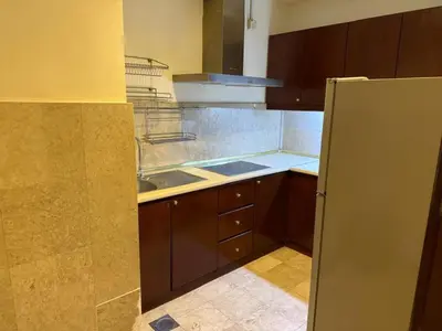 a kitchen with wooden cabinets and a refrigerator at KL Suite at Times Square in Kuala Lumpur