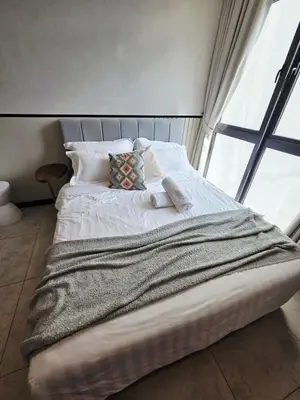 a bed in a room with a large window at Chillax Studio Near KLCC Gleneagles in Kuala Lumpur