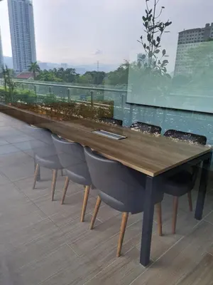 a long wooden table with chairs on a roof at Chillax Studio Near KLCC Gleneagles in Kuala Lumpur