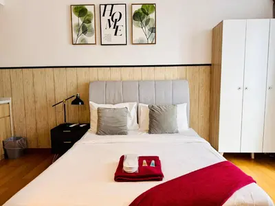 a bedroom with a large bed with a red bag on it at The Luxe & Colony KLCC By Downtown Suites in Kuala Lumpur