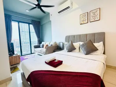 a bedroom with a large bed and a living room at The Luxe & Colony KLCC By Downtown Suites in Kuala Lumpur