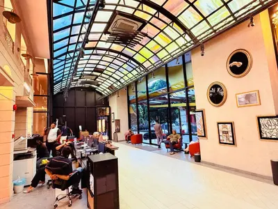 a lobby with people sitting at tables in a building at Scarletz Luxury Suites KL in Kuala Lumpur