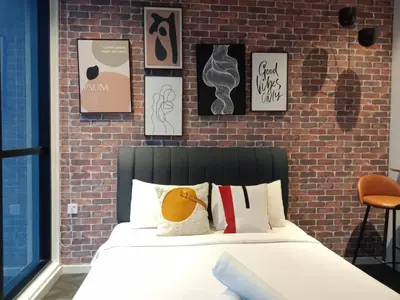 a bedroom with a bed and a brick wall at Scarletz Suites Klcc Twin tower by Lucky in Kuala Lumpur